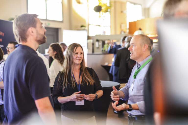 Teilnehmende im Gespräch an einem Partnerstand – AppSphere Innovation Day 2025 in der Kulisse Ettlingen