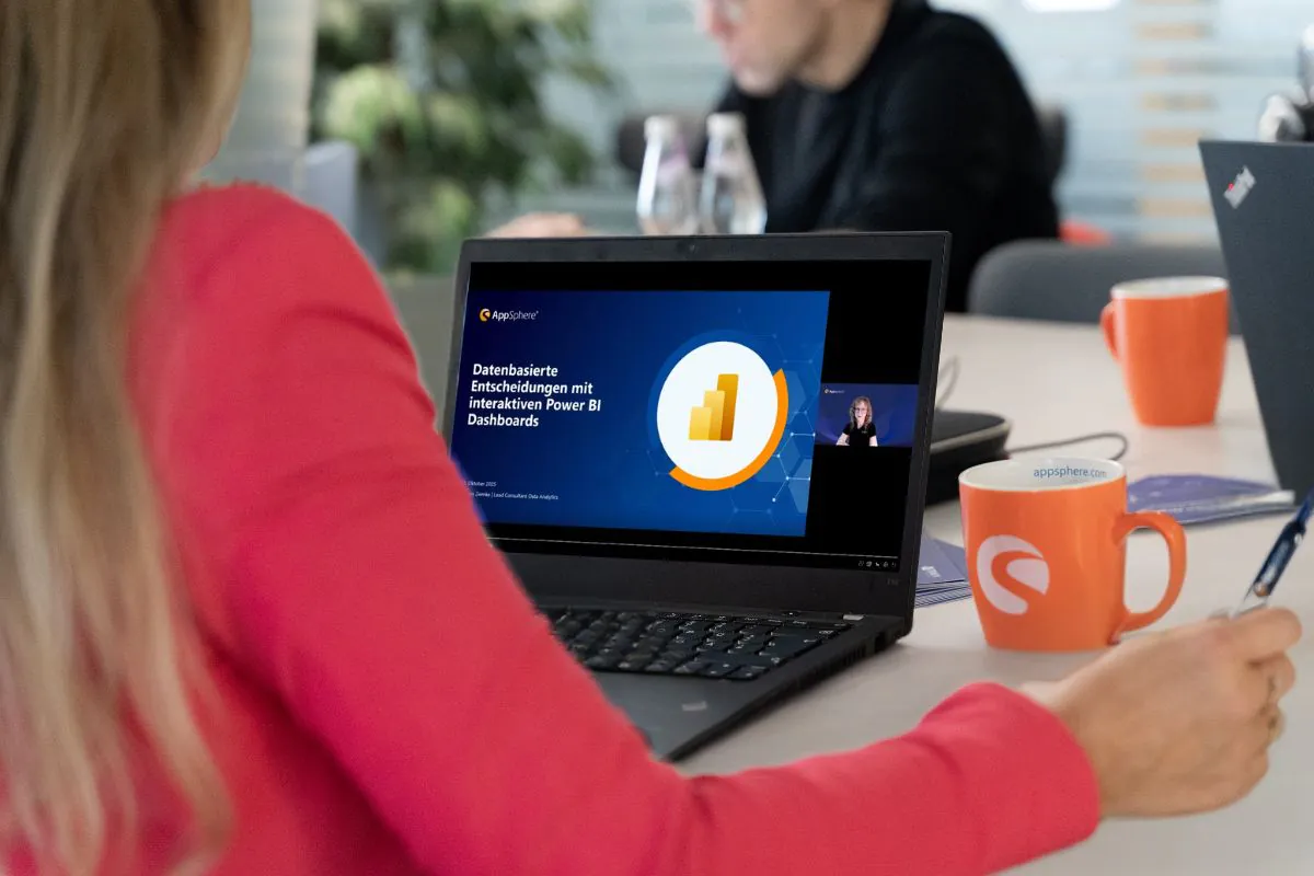 Teilnehmende einer Online-Session von AppSphere verfolgen eine Präsentation zur Power BI Einführung im Unternehmen auf dem Laptop, Thema datenbasierte Entscheidungen mit interaktiven Dashboards.